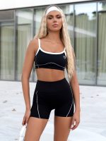 Black two-piece sports set leggings and bustier with white stitching