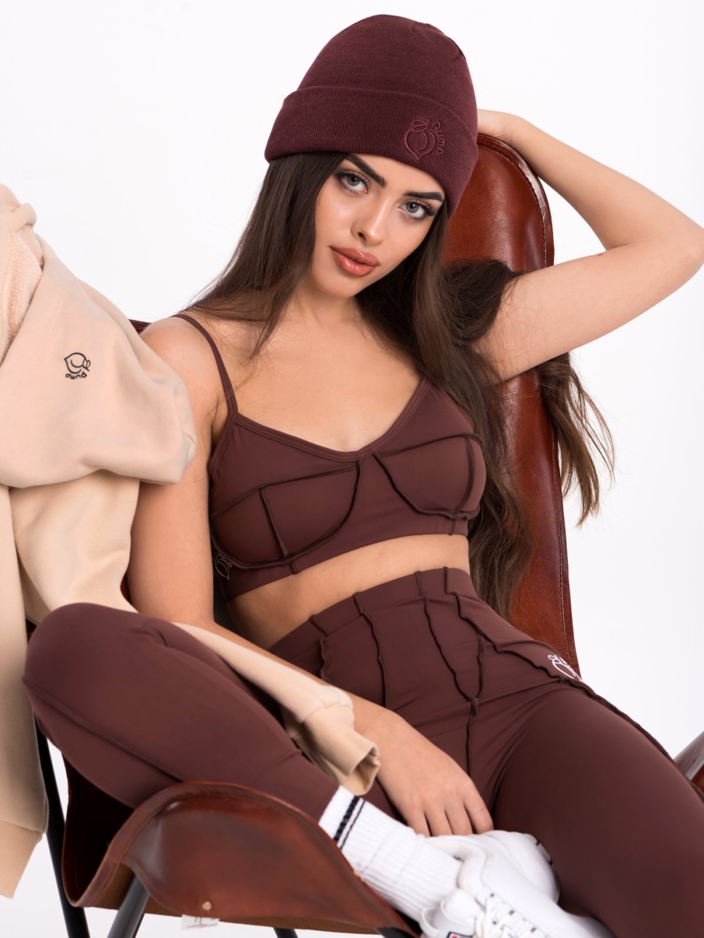 Dark brown winter hat with embroidered Peach Pump logo on the front