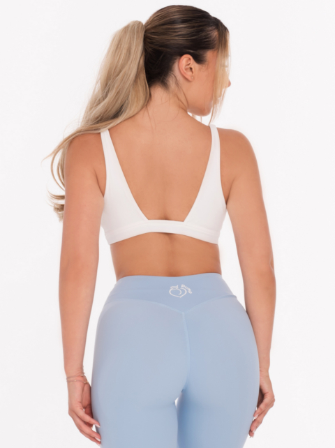 Biały, wycięty, seksowny biustonosz z głębokim dekoltem w kształcie litery V i efektownym tyłem.