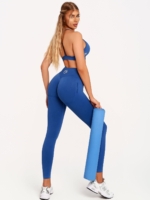 Women's blue leggings made from soft seamless fabric with Peach Pump branding knitted into the fabric.