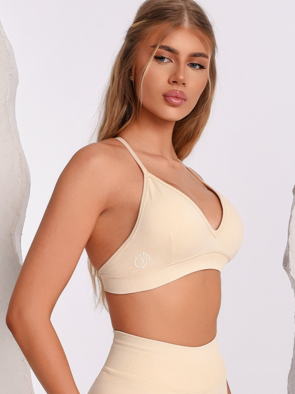 Beige sports bra with a V-neckline and an adjustable back strap for maximum comfort.
