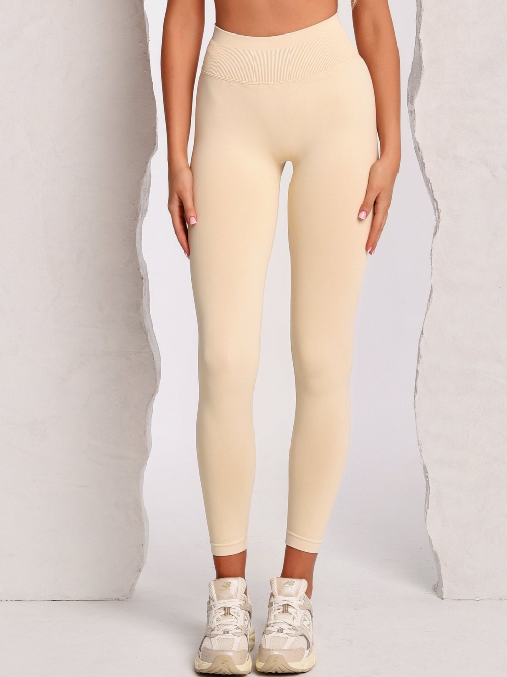 Women's beige leggings made from soft stretch fabric with Peach Pump branding knitted into the fabric.