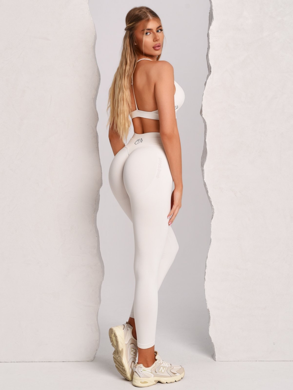 Seamless white leggings with Peach Pump branding knitted into the fabric along the curves of the hips.