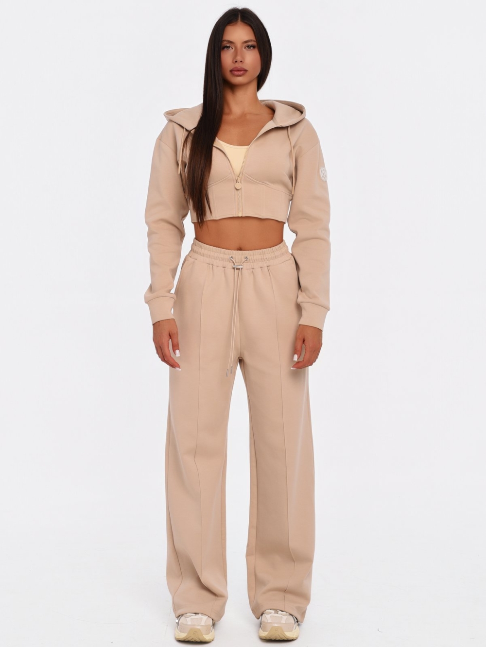 Women's beige gym set with adjustable wide leg joggers.