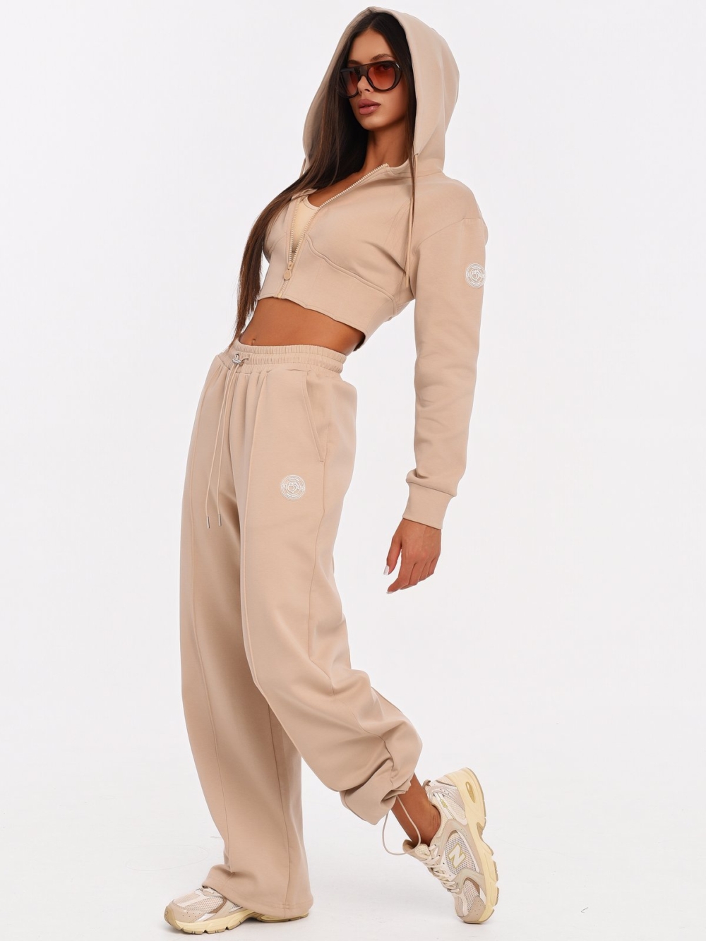 Women's beige joggers with metal details and an adjustable waistband.